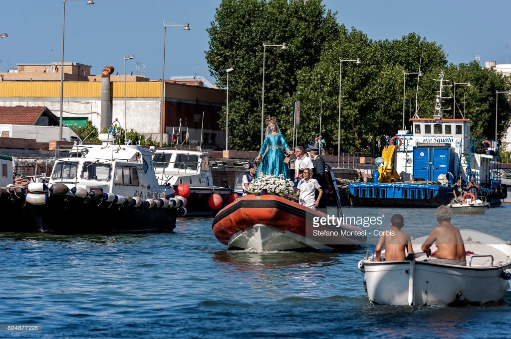 ROME, ITALY - JULY 30: A boat carries the Madonna fiumarola 'river Mary,' down Tiber river in Fiumicino, city lies on the northern side of the mouth of the Tiber River, during the procession along Rome's Tiber River as part of the traditional Festa di Noantri on July 30, 2017 in Rome, Italy. The feast was instituted in 1927, but its origin dates back to the 16th century. In 1535, after a violent thunderstorm, a statue of Mary carved out of cedar wood washed up on the shores of the Tiber. She was brought up the river and given to the then Carmelite church of St. Chrysogonus. (Photo by Stefano Montesi - Corbis/Corbis via Getty Images)